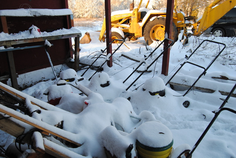 Lawn mowers covered with snow.