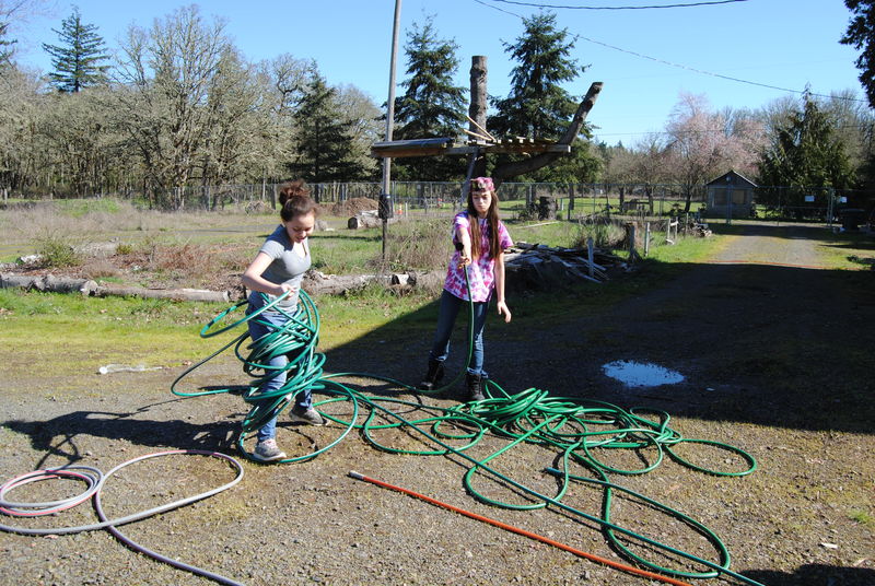 Shannon and Latia winding a hose.