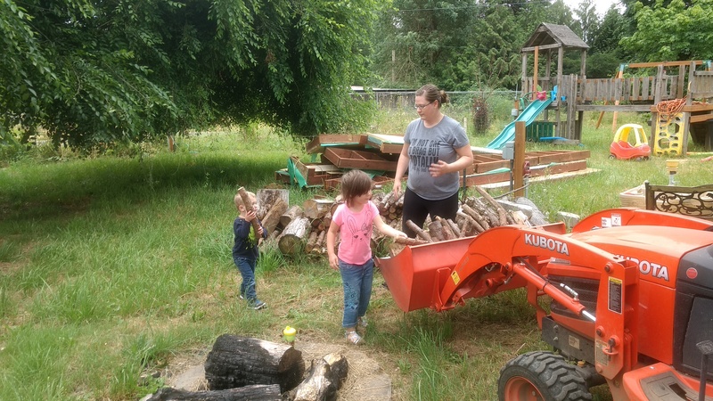 Stacia works with Emily and Austin to load firewood into Goldie.