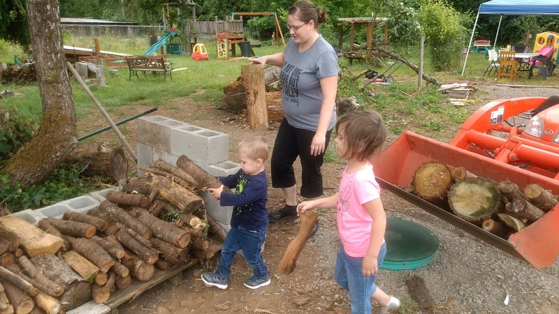 Stacia, Austin, and Emily carefully load the firewood rack.