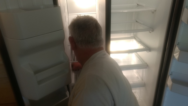 Don cleans out the freezer of all its packing tape.