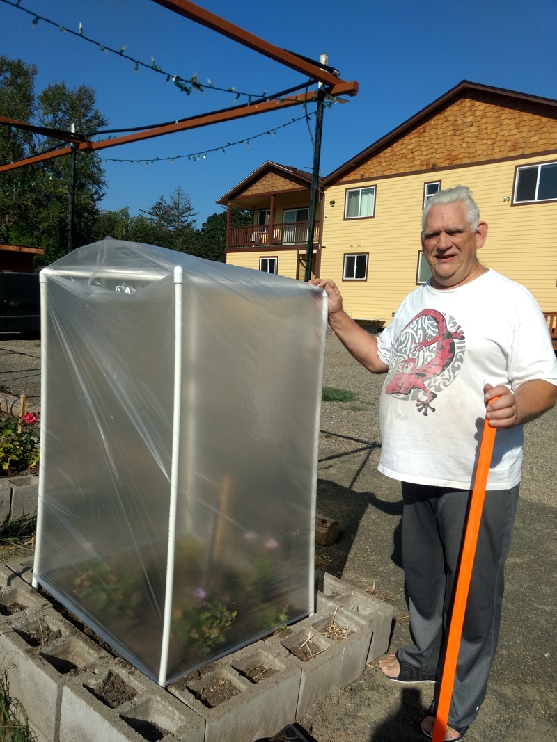 Don stands next to our new Mini Greenhouse. It has been a fun project.