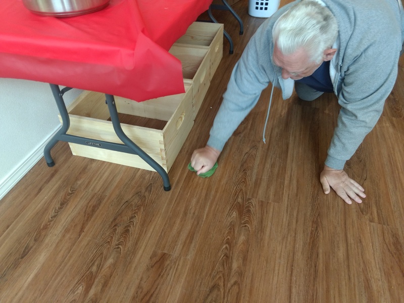 Don cleans up honey from the floor.