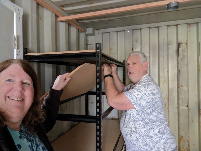 Lois and Don reassemble storage shelving.