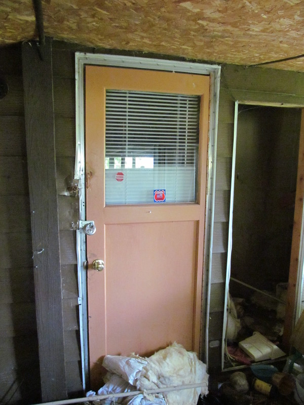 Door from North Wing to Utility Room, hole for Hot Water Heater. Carport1.