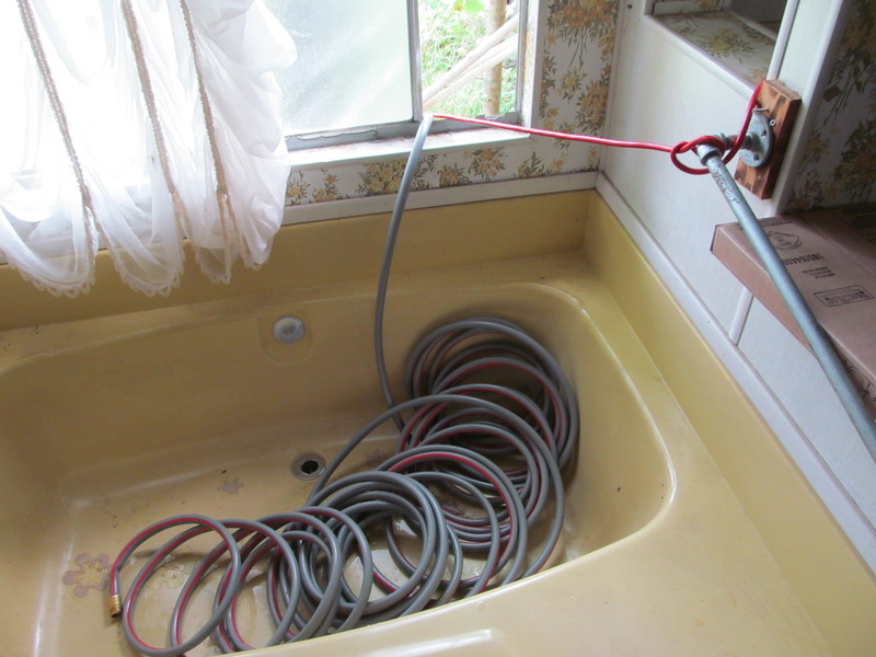 So here's our fancy way to fill the toilet tank. Water and electricity coming through the MB window. You plug in the electrical cord and it starts the pump and voila, water comes out the hose. :-)