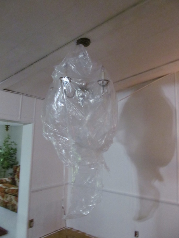 Chandelier covered with plastic for painting