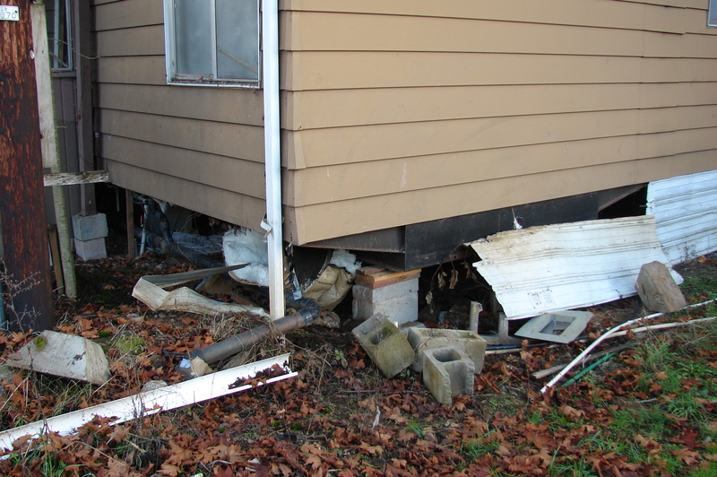 Siding where the water enters the house. Power pole.
