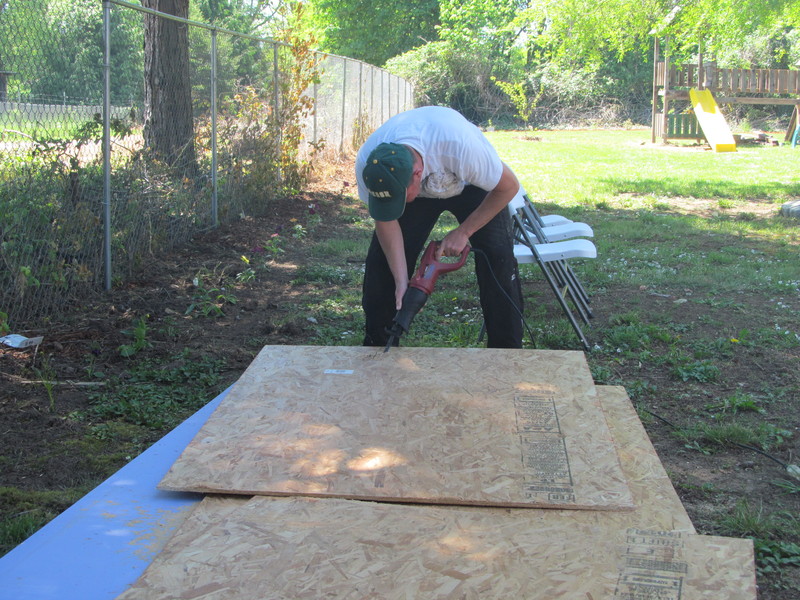 Chuck is cutting wood for the bathroom remodel. Play structure in the background.