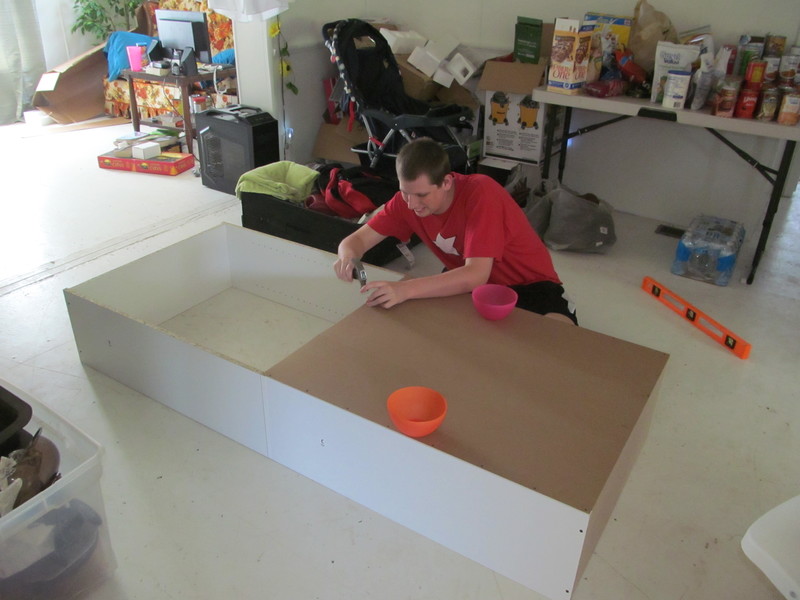 Isaac building a bookcase.