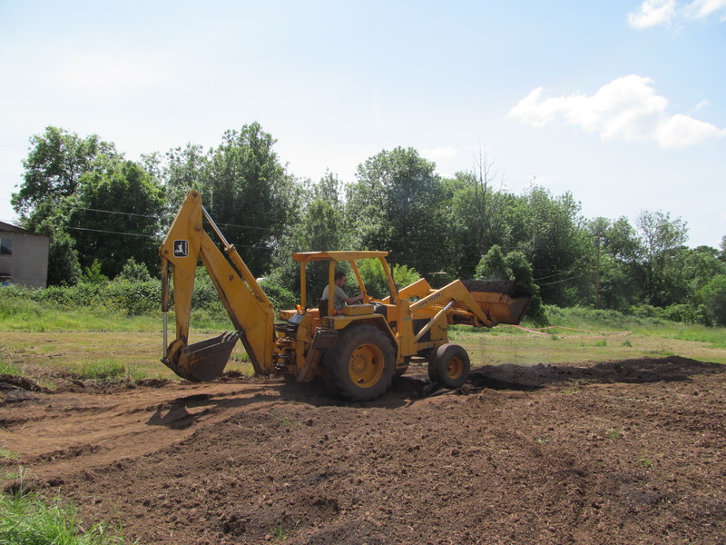 Chuck putting gardening soil onto the newly rototilled farm.