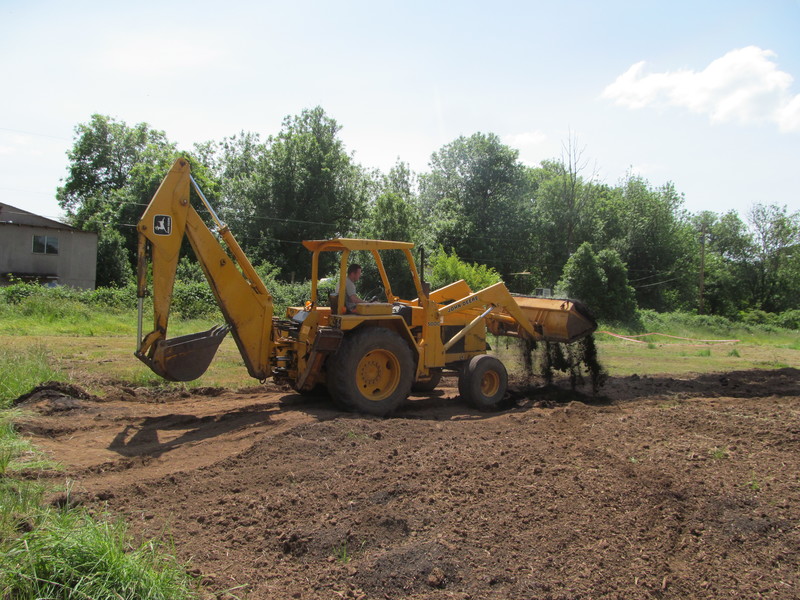 Chuck putting gardening soil onto the newly rototilled farm.