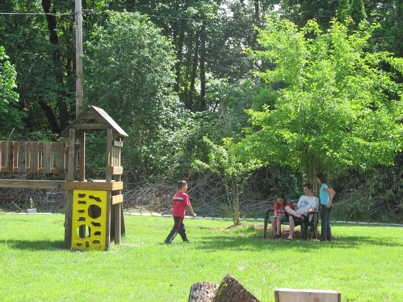 Kids enjoy a bench near the play structure.