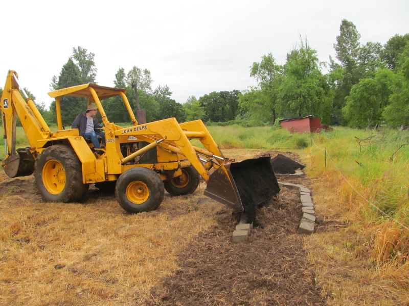 Goliath the Backhoe puts compost in south herb garden.