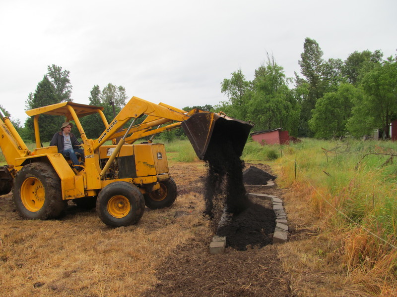 Goliath the Backhoe puts compost in south herb garden.