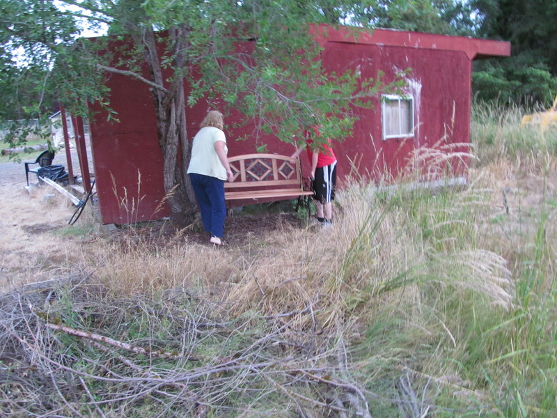 Lois and Isaac place the bench by the red shed for now. Now we need to mow our view. :-)
