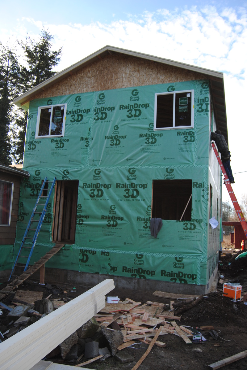 The house is wrapped. East wall is shown. Lois has two windows installed.