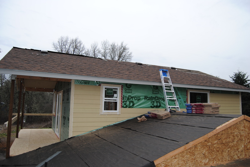 View of the south face of the addition. Siding has been added. Shingles have been added to the rooftop of the addition.