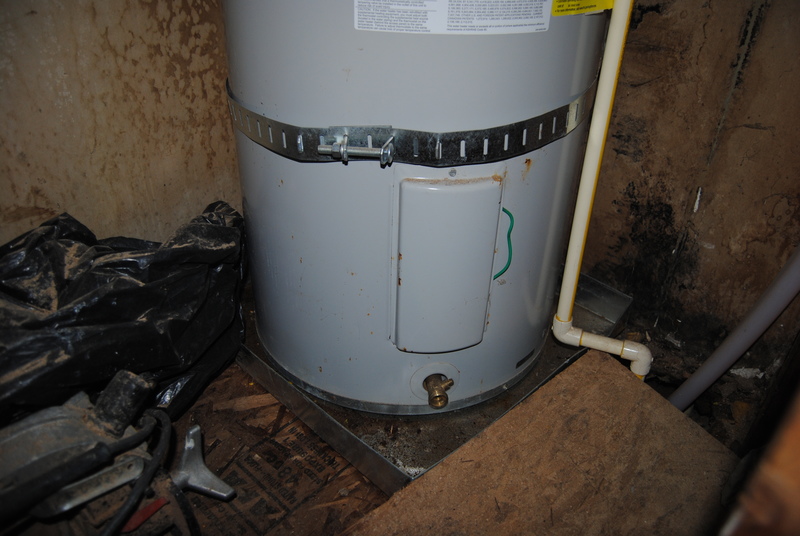 Water heater strapped into place to avoid damage in an earthquake. Lower access panel.