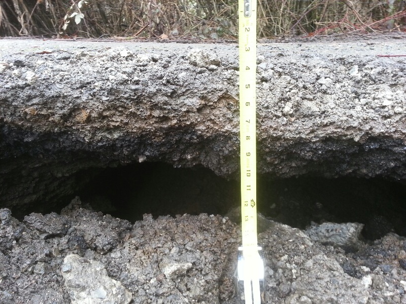 Culvert sinkhole. Measuring tape shows 3 inches at the top and probably 17 inches at the bottom, plus 2 inches for the spool casing, for a total of 16 inches of drop.