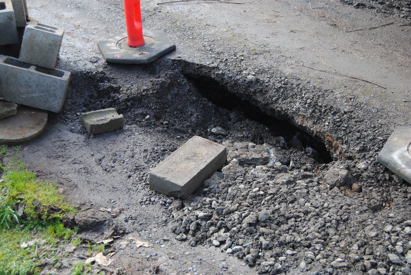 Culvert sinkhole. There is asphalt forming a bridge, and crushed rock on top of that. Based on other measurements it is about a 16-inch drop. The hole is small today compared to Feb24, judging by the center of the roadway.