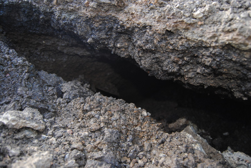 Culvert sinkhole. Closeup of the asphalt and the space under it right at the subsidence line.