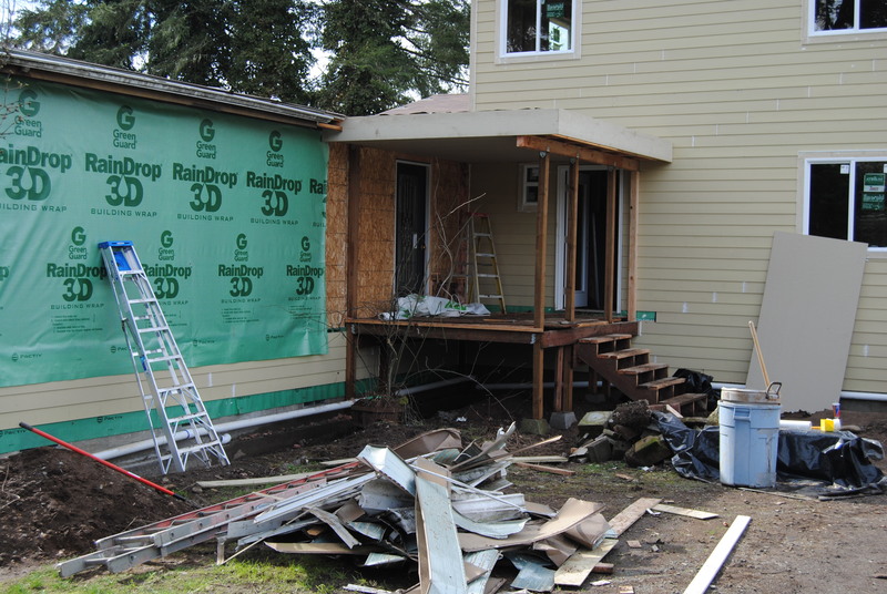 Building wrap applied to the east half of the north side. Front porch progress.