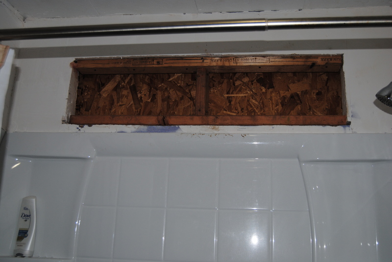 Bathroom window has been removed and replaced by plywood.