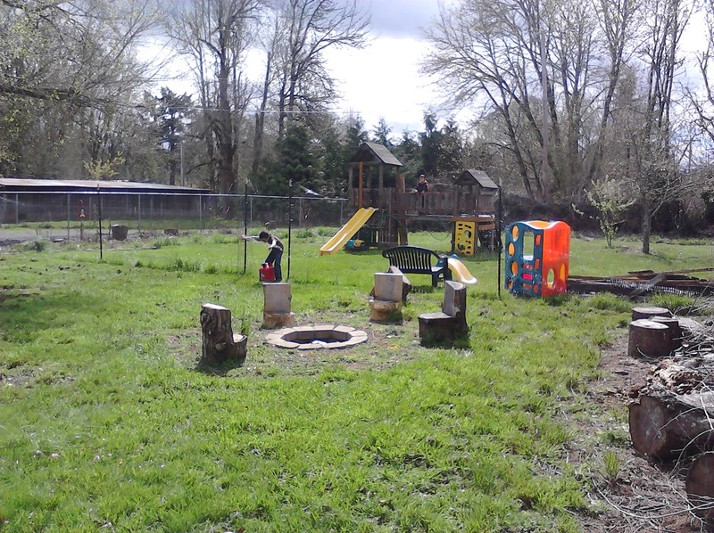Fire pit and the deer fence.  Mikey is bringing the gas can back.  Alex is making sure the play structure is still usable.