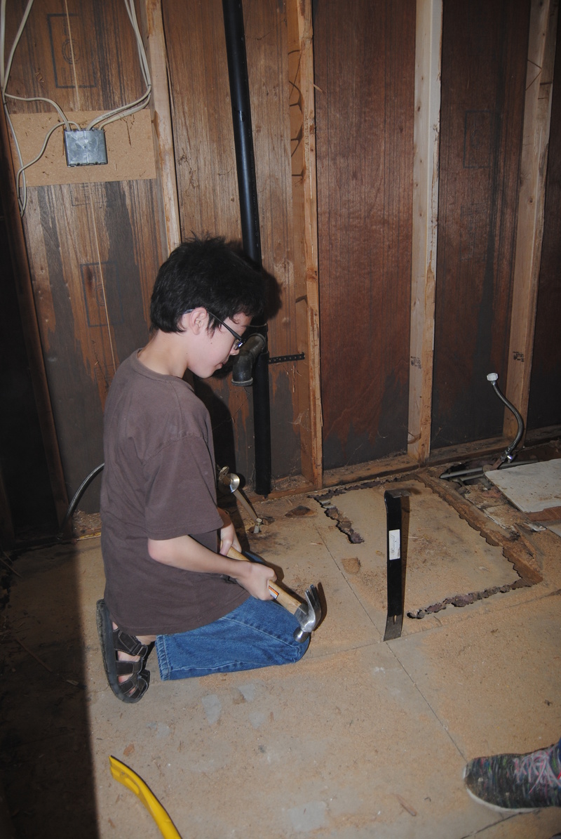 Mikey working on removing a section of flooring.