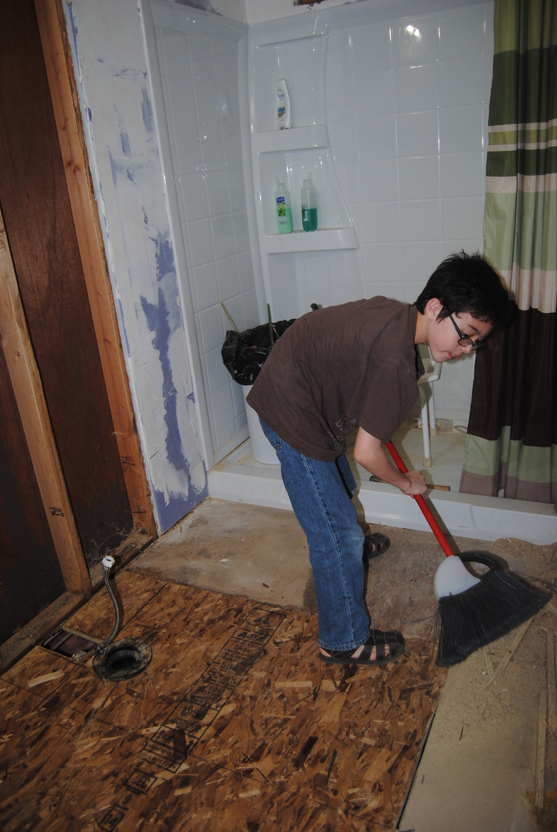 Mikey sweeping the bathroom floor.