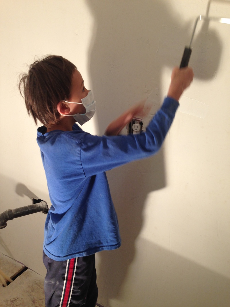 Alex painting the bathroom wall with primer.