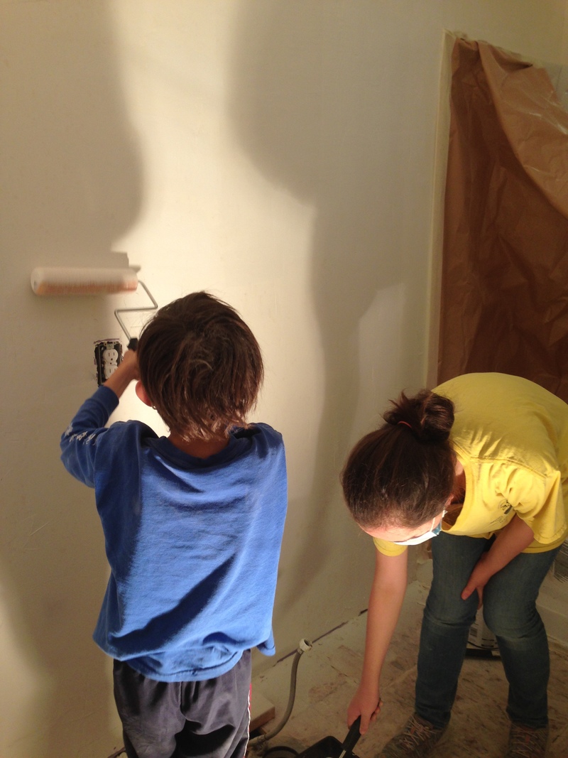 Alex and Shannon painting the bathroom wall with primer.