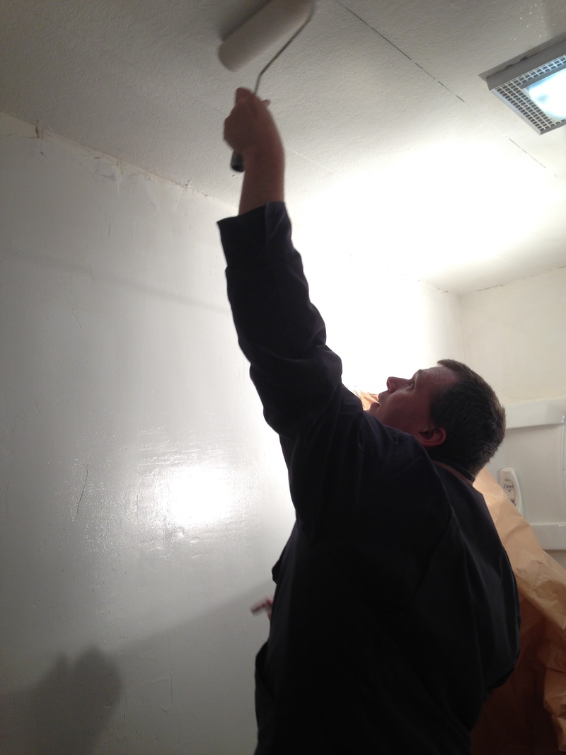 Joseph painting the bathroom ceiling.