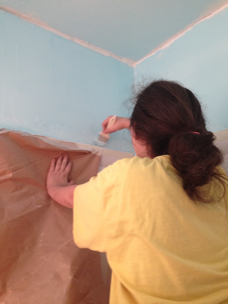 Shannon painting edges with light blue paint.