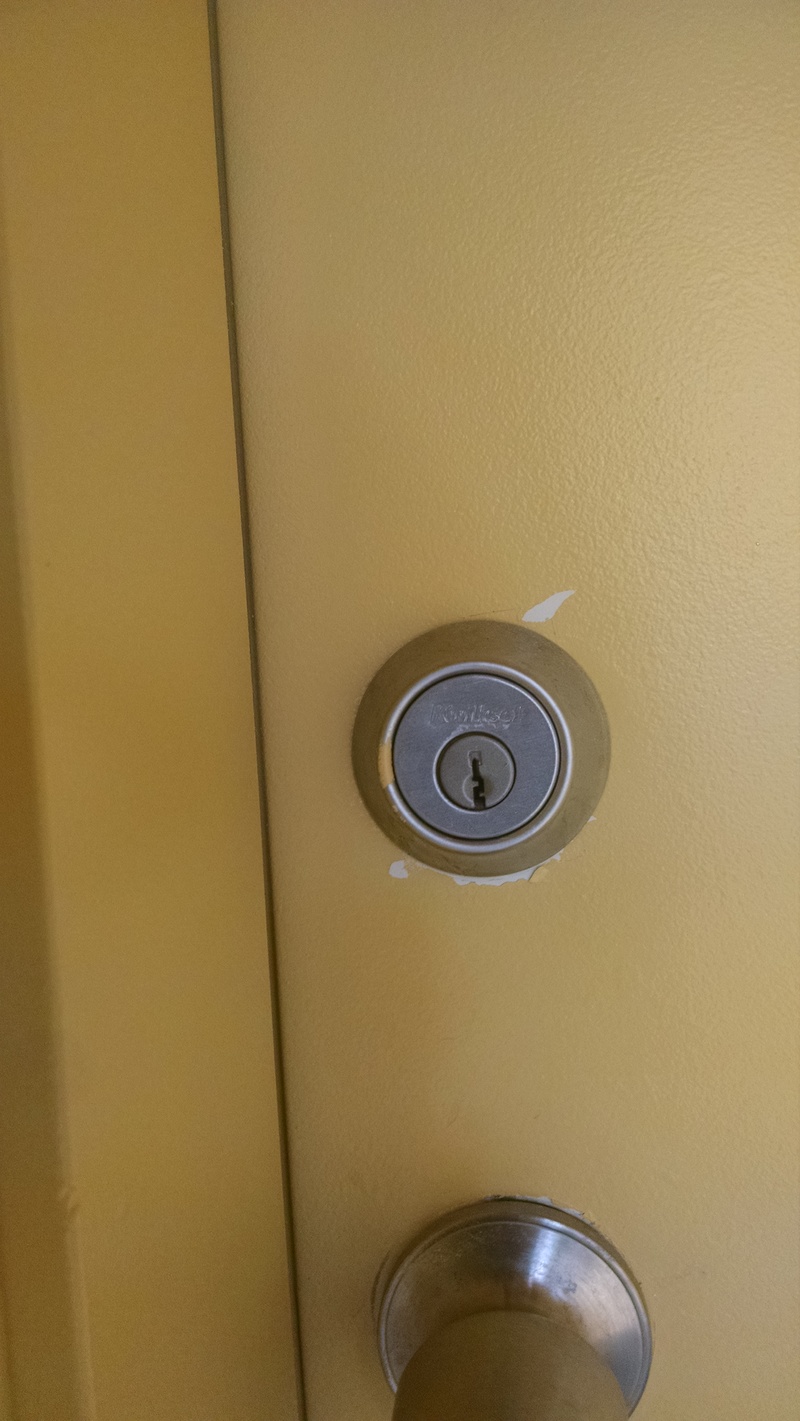 detail of a door lock with some paint touch-up needed.