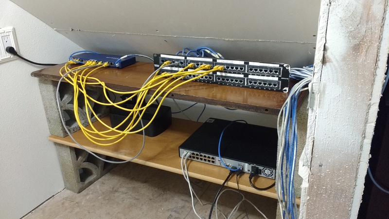This is the newly improved network closet. Top left is the electrical outlet. Next is the switch. Finally the patch panel. Bottom left is the UPS (uninterruptible power supply) and then the Swann DVR that powers our camera system.
The inspector said that the closet had to have sheetrock. It was hard to sheet rock.