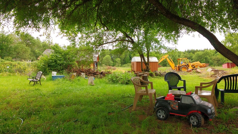 Joseph runs Goliath, our backhoe, carrying tree rounds to where they will be used. The picnic area (foreground) is looking better each day.