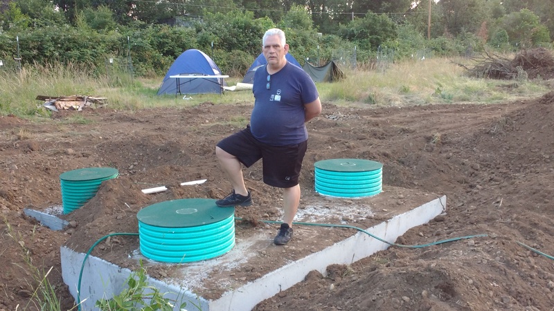 Don stands atop the septic tank. 3000 gallons. Two man-holes. To the left you can see the man-hole for the pump system on the 1000 gallon dosing tank.