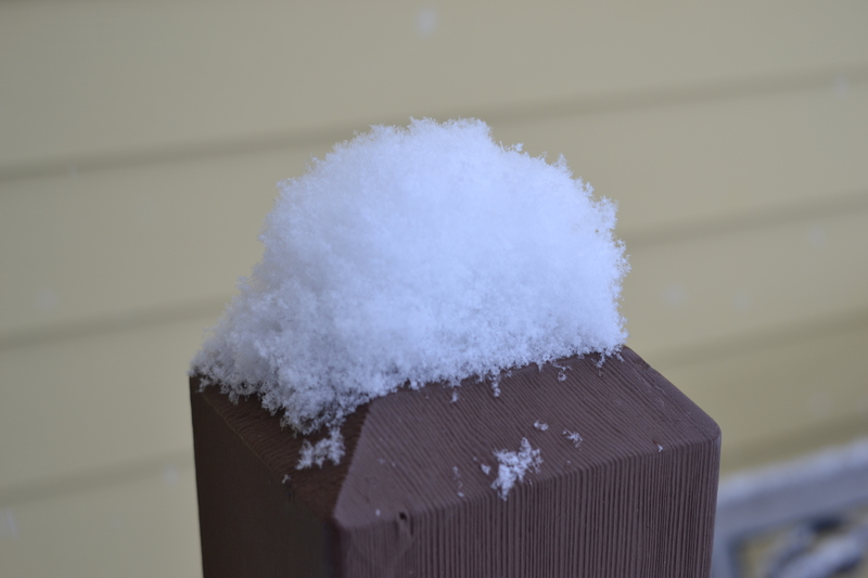 Snow on top of handrail post.
