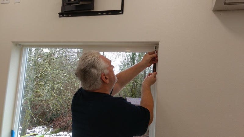 Don installs a bracket to hold up some mini blinds.