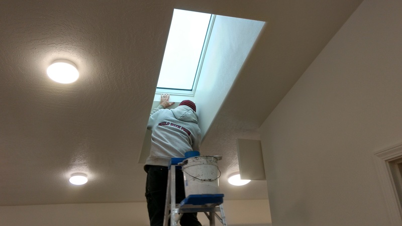 Rustin cleans and paints around a sky light.