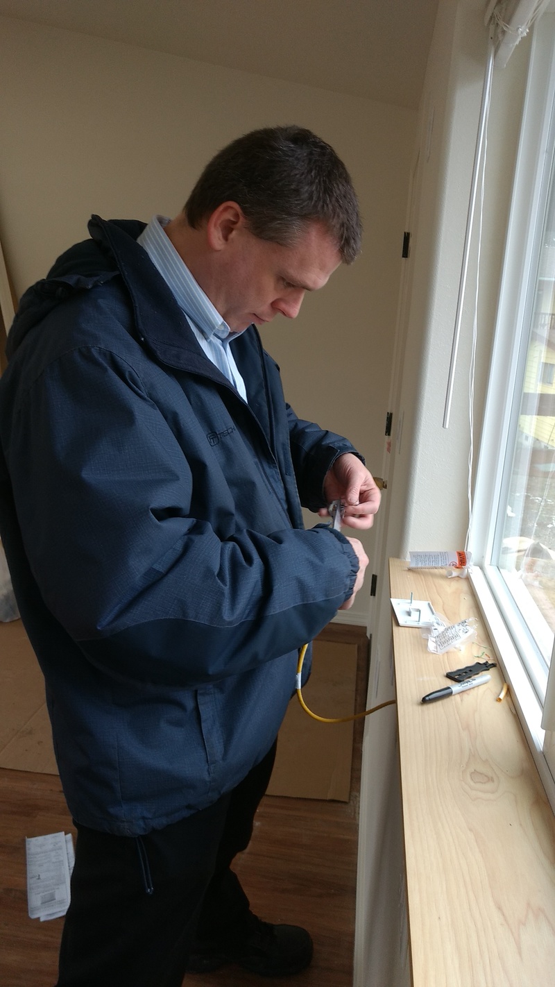 Joseph puts an RJ45 connector on the Cat6 wire.