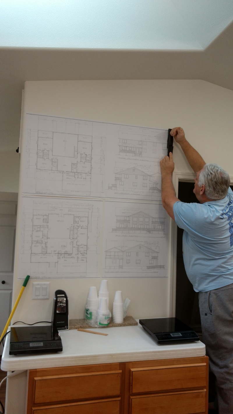 Don putting the Big House Plans on the wall of the guesthouse.