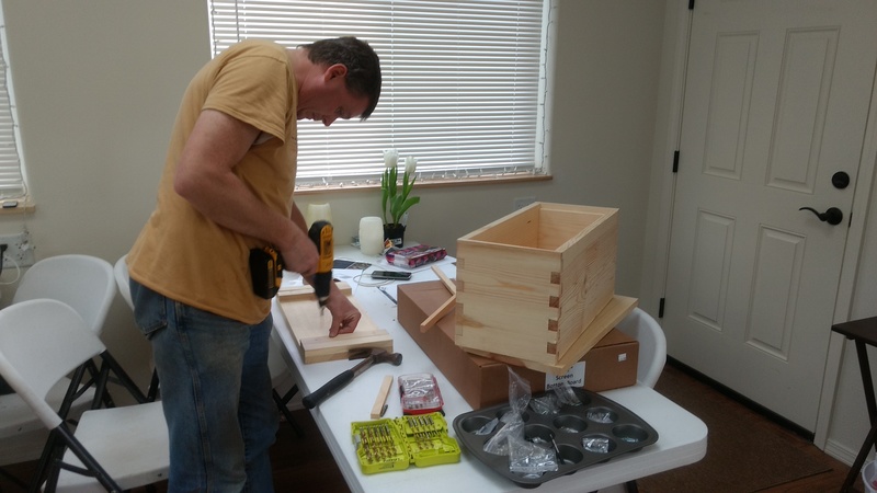 Joseph assembles a box for bees.