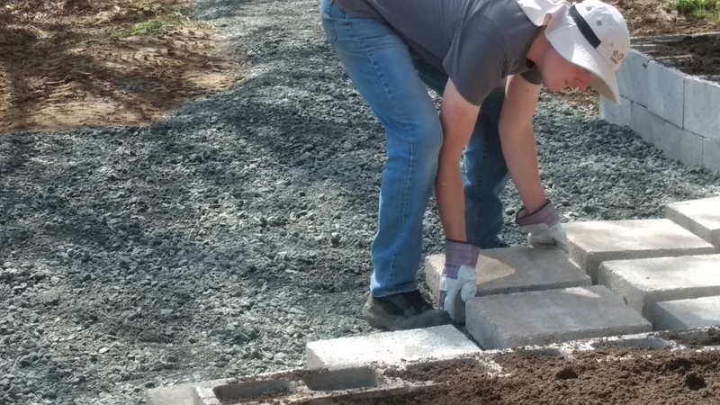 Joseph laying pavers in the new Greenhouse Patio.