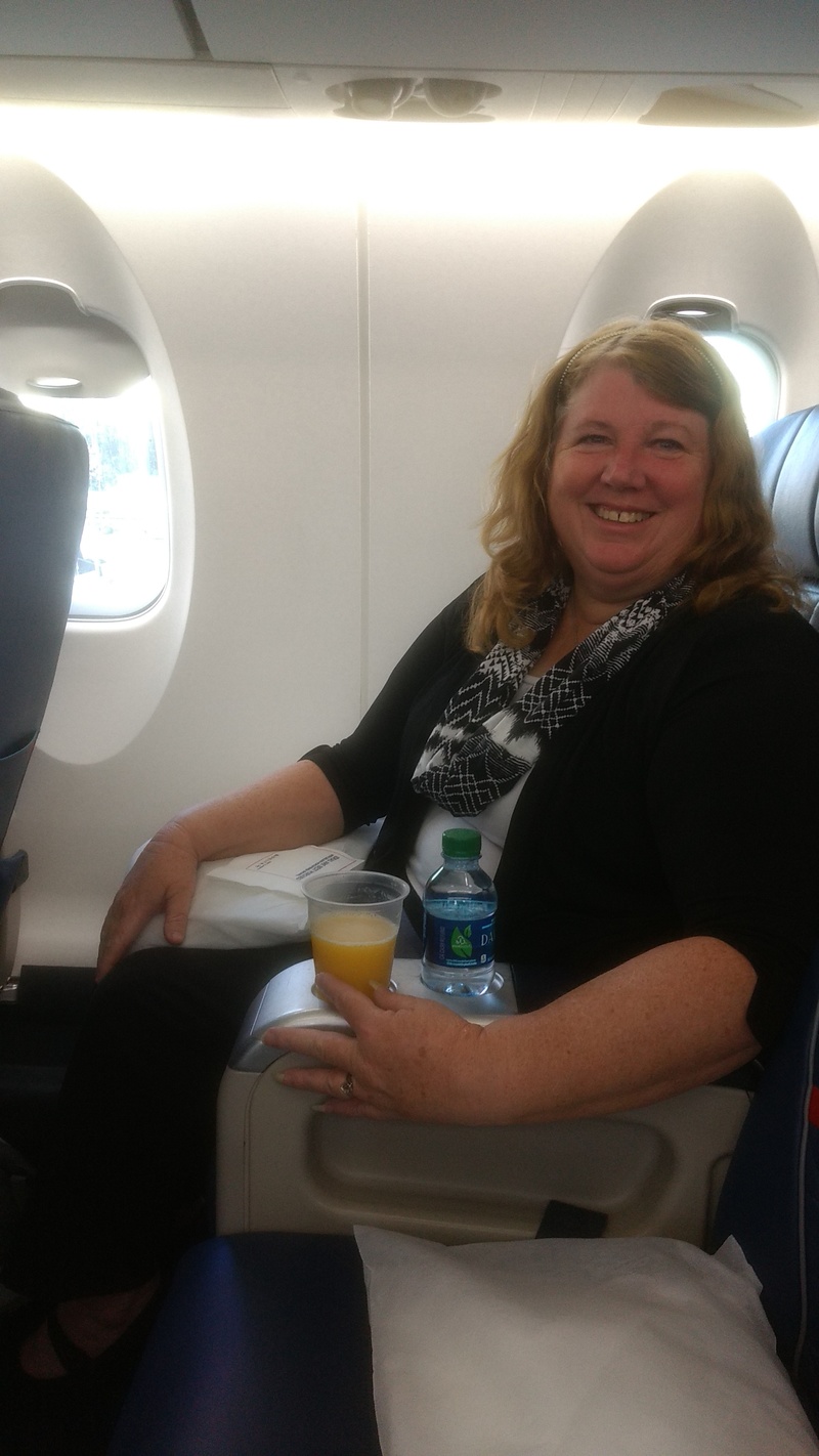 Lois enjoys a refreshing glass of orange juice on her first class flight to Utah.