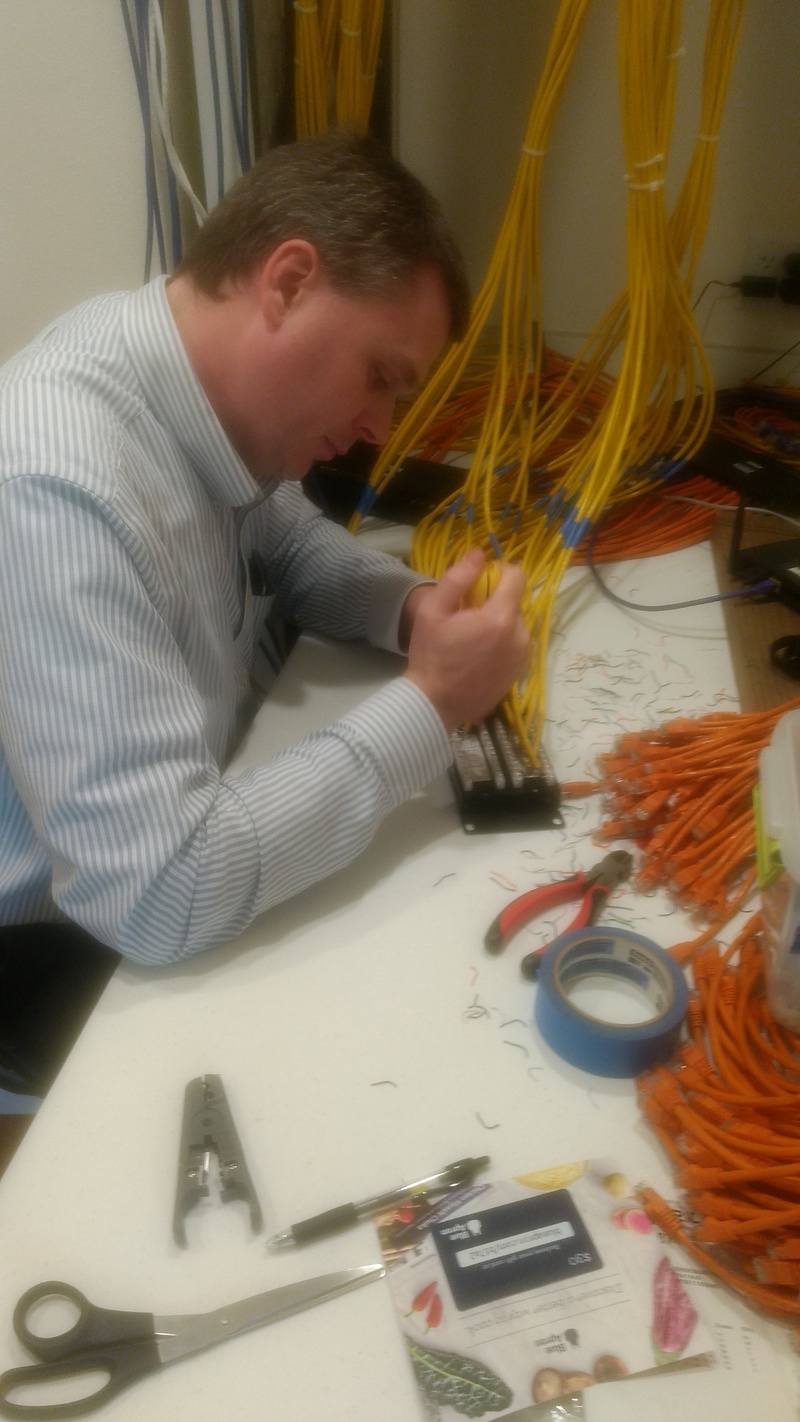 Joseph completes the punch-down of the networking wires.