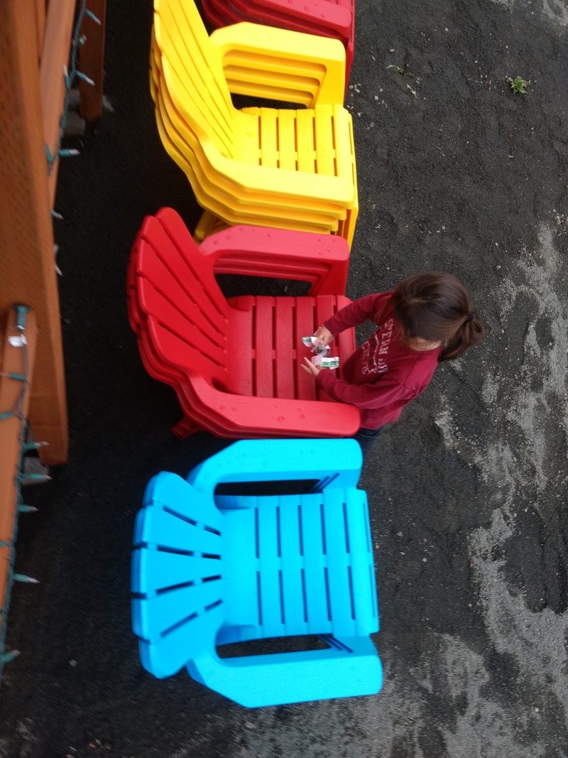 Kekoa removes labels from the Adirondack chairs.