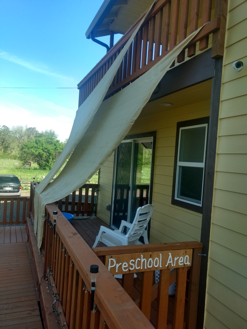 Triangular "sails" drape across the rm4d deck, aka the Preschool Area, to provide midday and afternoon shade.